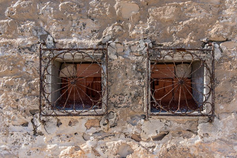 quadratische, verrostete Fenstergitter in Steinnmauer auf Djerba