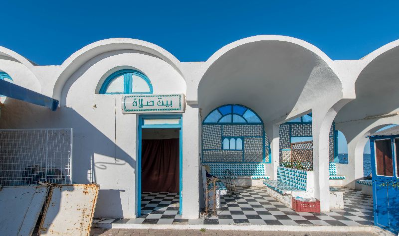 verlassene Ferienanlage auf Djerba mit blau weiß gekachelten Betonbänken unter weißen Kuppeldächern