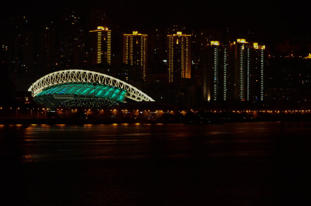 Nachtaufnahme von ähnlichem Gebäude wie die Oper von Sydney in grün leuchtend in China