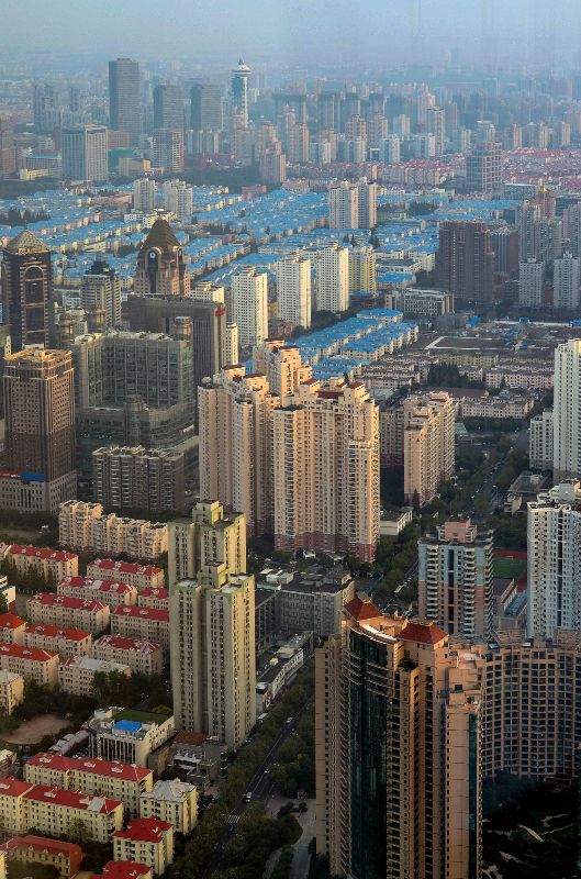 Foto vom Tower in Shanghai nach unten auf die Hochhäuser im Dunst