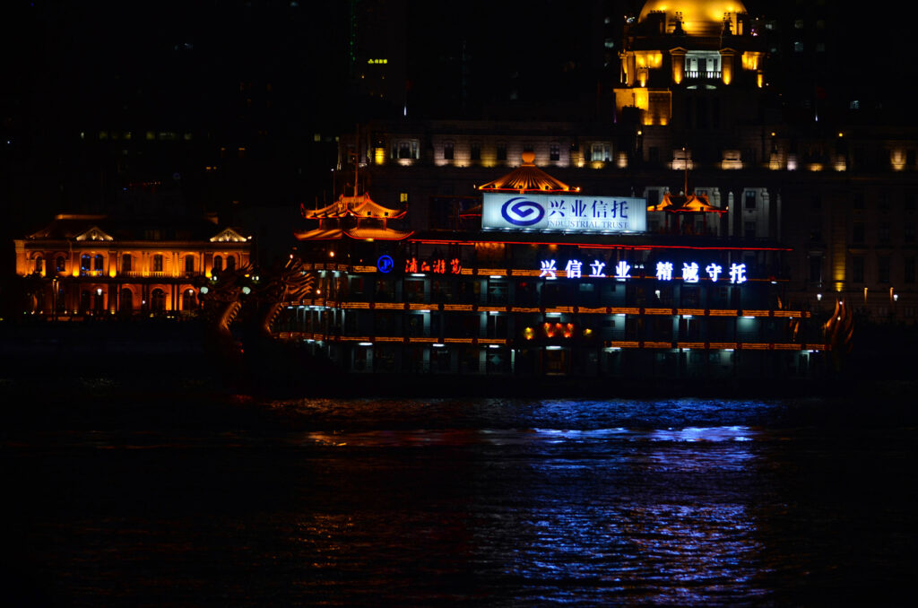 Nachtaufnahme von Drachenboot-Restaurant auf dem Fluss in Shanghai