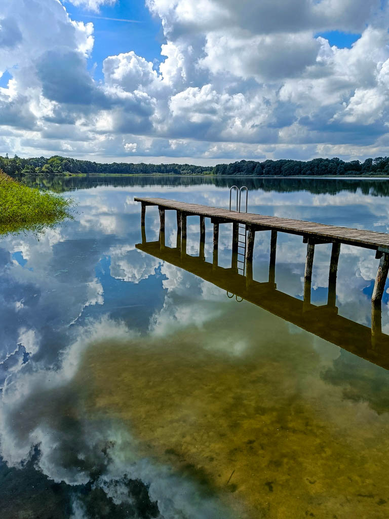 Spiegelung der Steganlage mit Wolken am Dambecker See