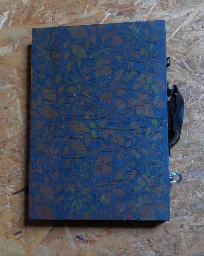 alte Holzkiste nußbaumfarben mit Krinkeloptik in Blau mit Blattwerk