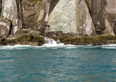 blaues Meer mit schäumenden aufkommenden Wellen an der Felswand in Dingle-Bay