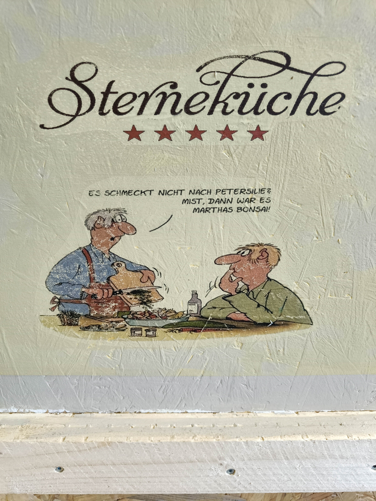 Comic von Uli Stein auf Spritzschutzwand vom Gasherd: Sterneküche - Es schmeckt nicht nach Petersilie? Mist, dann war es Marthas Bonsai!