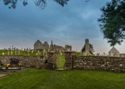 Ansicht von Klosterruine Clonmacnoise vom Friedhof aus mit Steinmauer im Vordergrund