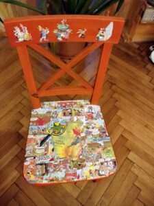 Asterix und Obelix-Comics auf altem orange gestrichenen Holzstuhl