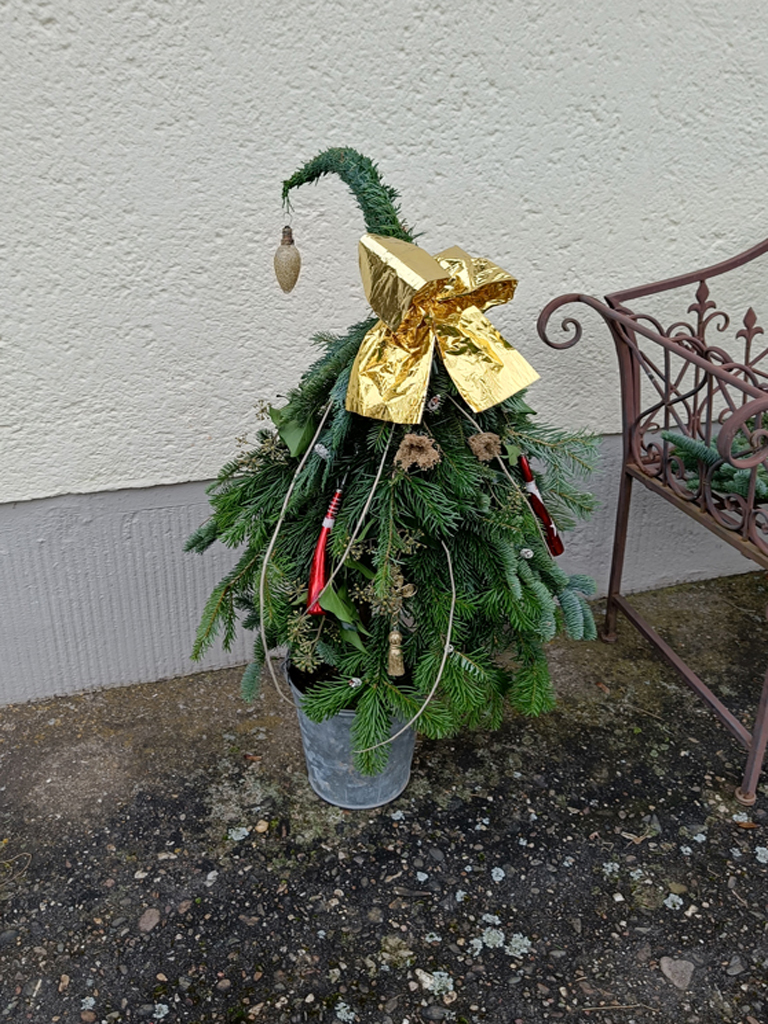 Weihnachtsbaum aus Zweigen mit goldener Schleife