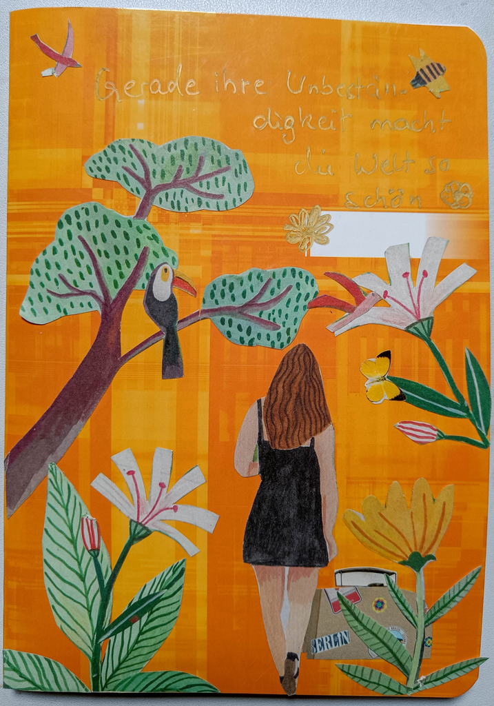 oranges Heft mit Papiercollage Frau unter Baum mit Tukan und großen Blumen