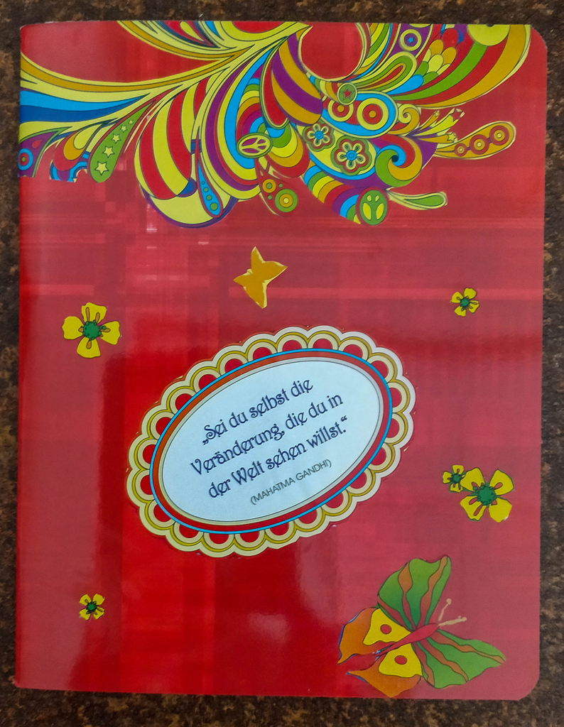 rotes Heft mit bunter Papiercollage von Blumen, Schmetterling und Muster