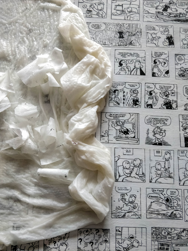 Aufsicht von Arbeitsprozeß mit nassem Papiertuch auf gepotchte Comic-Fläche