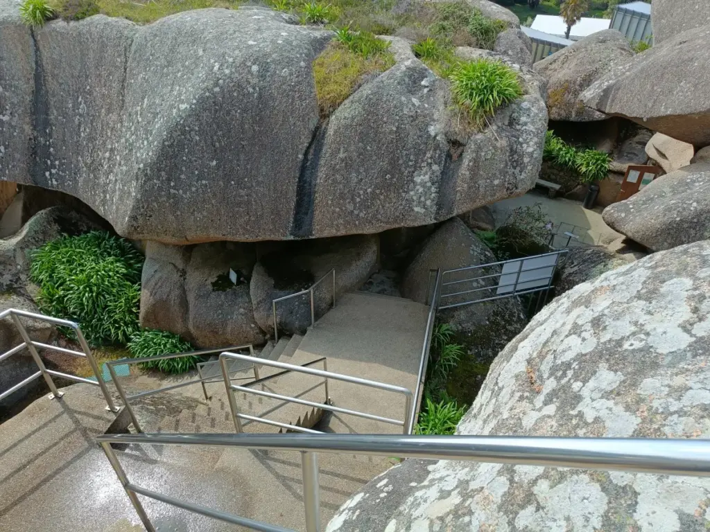 Innenansicht Aquarium Trégastel, die Aquarien stehen hier in rosa Granithöhlen, eine Treppe führt zur Statue oberhalb an einem Wasserfall vorbei