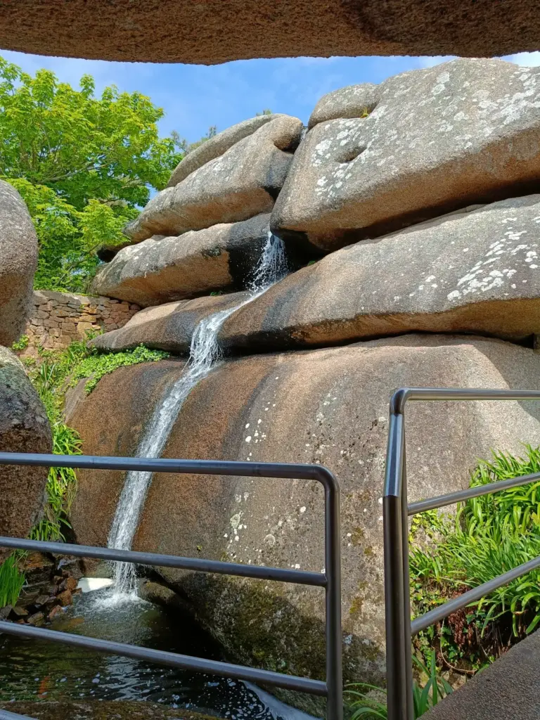 Wasserfall über riesige runde rosa Granitblöcke im Aquarium Trégastel