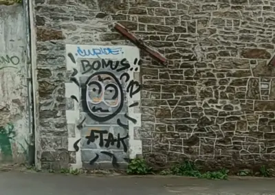 Graffity in grau-Tönen mit Gesicht auf Mauer in der Umgebung von Cap Frehel