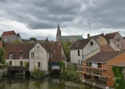Kathedrale von Chartres im Hintergrund Seitenansicht und vorne der Fluß Eure mit alten Häusern wo er durchfließt