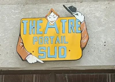 gelbes Theaterschild Portail Sud an Hauswand mit Clown der einen Hut lüftet