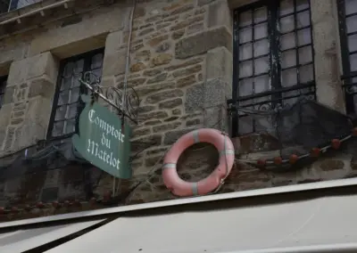 Schild über Boutique mit Rettungsring über Markise in Ville Close Concarneau