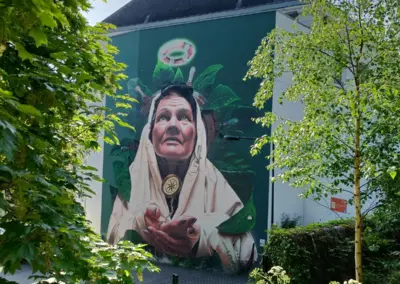 Graffiti von älterer Frau, die nach oben schaut und einen Rettungsring über Blättern am Kopf schweben hat