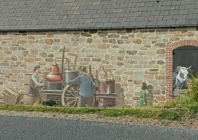Wandgemälde auf Scheune mit zwei Bauern, einer Kuh und eines Holzkarrens mit einer Destillieranlage von früher