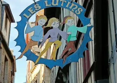 ein altes Schild mit 3 Elfen drauf im Dorf von Mont Saint Michel