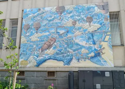 Illustration in Blau von der Stadt Saint Brieuc mit darüber fliegenden Zeppelin und Ballons in grau-braun Tönen.