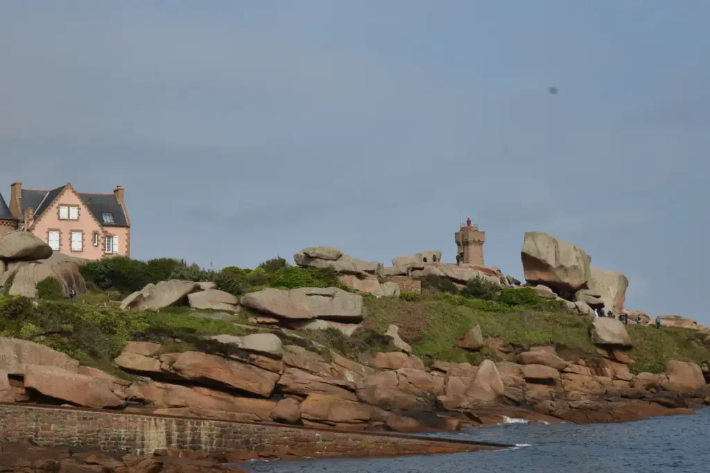 Granitküste mit Leuchtturm von Ploumanac’h hinter Seenotrettung Bootsstation