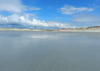 Ausblick vom Meer über großen Sandstrand zur Düne in Tronoën